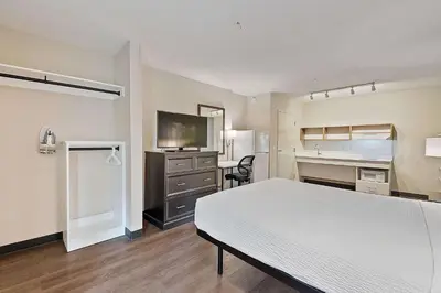 a bedroom with a bed and a desk and a sink at Extended Stay America Suites - Miami - Airport - Blue Lagoon in Miami