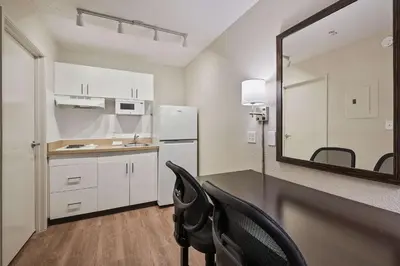 a kitchen with a table and a mirror in a room at Extended Stay America Suites - Miami - Airport - Blue Lagoon in Miami