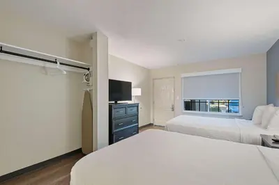a hotel room with two beds and a television at Extended Stay America Suites - Miami - Airport - Blue Lagoon in Miami