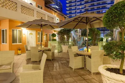 a restaurant with white chairs and tables and umbrellas at Sun Harbour Boutique Hotel in Miami Beach