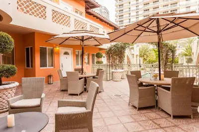an outdoor patio with tables and chairs and umbrellas at Sun Harbour Boutique Hotel in Miami Beach