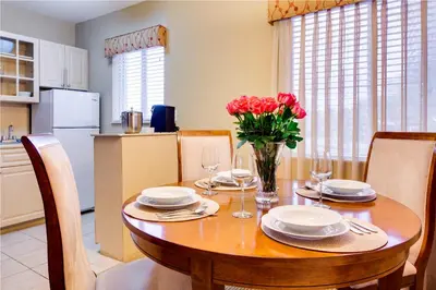 a dining room table with a vase of flowers on it at Sun Harbour Boutique Hotel in Miami Beach