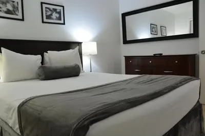 a bedroom with a large bed and a mirror at New Point Miami Beach Apartments in Miami Beach