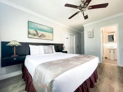 a bedroom with a large bed with a ceiling fan at Hollywood Beach Hotels in Hollywood