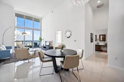 a dining room and living room with a table and chairs at Icon Brickell Residences in Miami