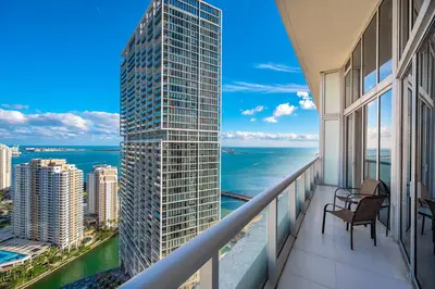 a balcony with a view of the ocean and a skyscraper at Icon Brickell Residences in Miami