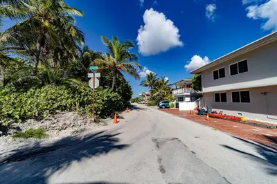 an empty street in front of a house with palm trees at The Desoto - Oceanview Inn in Hollywood