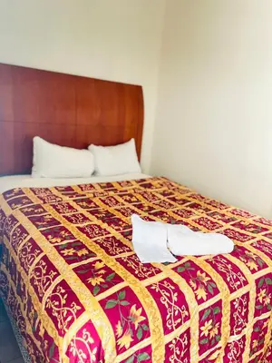 a bed with two towels sitting on top of it at Miami Springs Inn in Miami