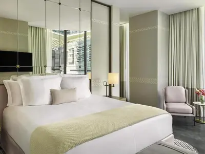 a bedroom with a large white bed and a chair at SLS LUX Brickell in Miami