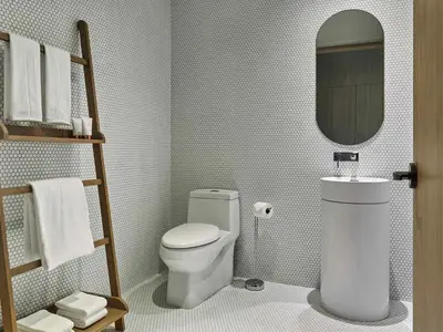 a bathroom with a white toilet and a mirror at SLS LUX Brickell in Miami