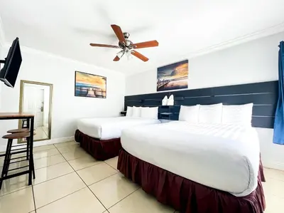 a hotel room with two beds and a ceiling fan at Ocean Villas in Hollywood