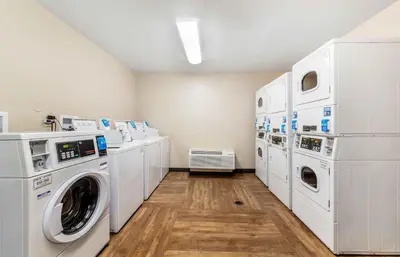 a laundry room with white washers and dryers at Extended Stay America Premier Suites - Miami - Airport - Doral - 87th Avenue South in Miami