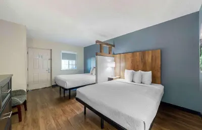 a bedroom with two beds and a blue wall at Extended Stay America Suites - Miami - Airport - Doral in Miami