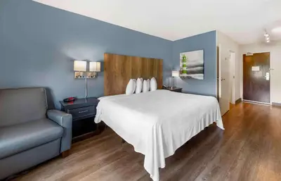 a bedroom with a white bed and a couch at Extended Stay America Premier Suites - Fort Lauderdale - Convention Center - Cruise Port in Fort Lauderdale