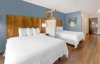 a hotel room with two beds and blue walls at Extended Stay America Premier Suites - Fort Lauderdale - Convention Center - Cruise Port in Fort Lauderdale