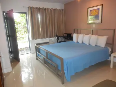 a bedroom with a large bed with a blue blanket at Shalimar Motel in Miami