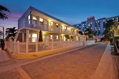 a house with a white fence on a street at Laguna Blu Beach in Hollywood