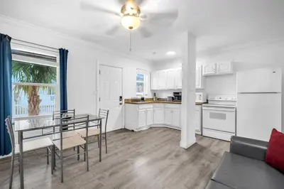 a kitchen and dining room with white cabinets and a table at Laguna Blu Beach in Hollywood