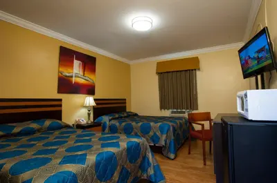 a hotel room with two beds and a flat screen tv at King Motel - Miami in Miami