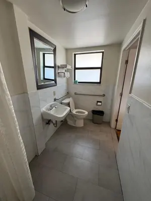a bathroom with a toilet and a sink and a window at King Motel - Miami in Miami
