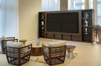 a living room with a large television and chairs at DoubleTree by Hilton Miami Doral in Miami
