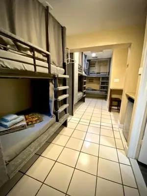 a room with bunk beds and a tiled floor at Sheridan Hostel in Dania Beach