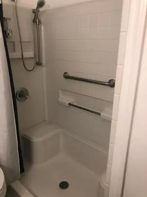 a bathroom with a shower with a tub and a toilet at Sheridan Hostel in Dania Beach
