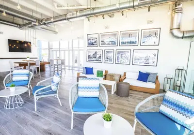 a living room with blue chairs and tables at Bahia Mar Fort Lauderdale Beach - DoubleTree by Hilton in Fort Lauderdale