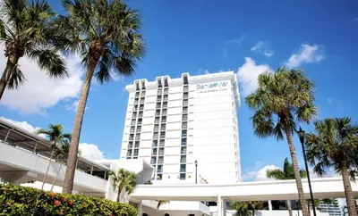 a white building with palm trees in front of it at Bahia Mar Fort Lauderdale Beach - DoubleTree by Hilton in Fort Lauderdale
