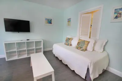 a bedroom with a bed and a flat screen tv at Hollywood Beachside Boutique Suite in Hollywood