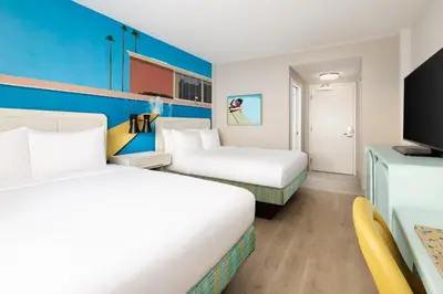 a hotel room with two beds and a tv at Hotel Continental Miami Beach, Tapestry Collection by Hilton in Miami Beach
