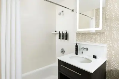 a white bathroom with a sink and a mirror at Hotel Continental Miami Beach, Tapestry Collection by Hilton in Miami Beach