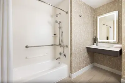 a bathroom with a tub and a sink and a mirror at Hotel Continental Miami Beach, Tapestry Collection by Hilton in Miami Beach