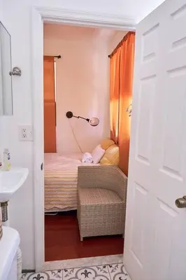 a bathroom with a bedroom with a bed and a lamp at Migue´s Tiny Miami Alcove in Miami