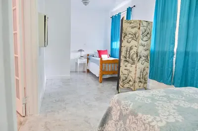 a room with a bed and a refrigerator in it at The Marlin Rooster Apartments in Miami