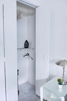 a white room with a table and a lamp at The Marlin Rooster Apartments in Miami
