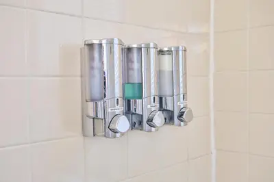a group of metal cylinders on a tiled bathroom wall at The Marlin Rooster Apartments in Miami