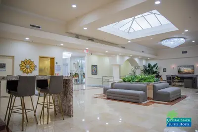 a lobby with a couch and a bar in it at Crystal Beach Suites Miami Oceanfront Hotel in Miami Beach