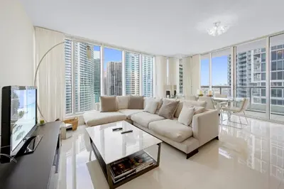 a living room with a white couch and a large window at ICON Brickell residences in Miami
