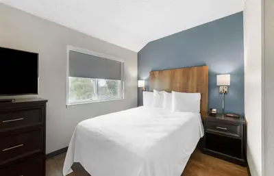 a bedroom with a white bed and a television at Extended Stay America Premier Suites - Miami - Airport - Miami Springs in Miami