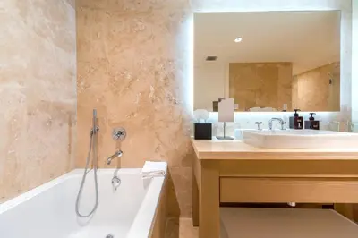a bathroom with a white tub and a sink at Oceanview Private Condo at 1 Hotel & Homes -906 in Miami Beach