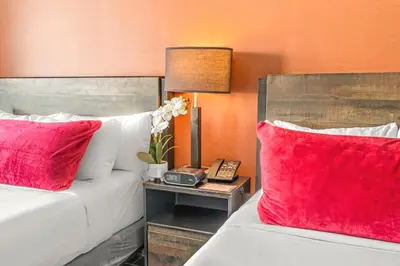 two beds with red pillows in a hotel room at The Fairwind Hotel in Miami Beach