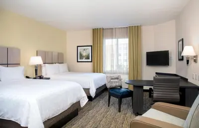 a hotel room with two beds and a desk at Candlewood Suites - Miami Exec Airport - Kendall by IHG in Kendall