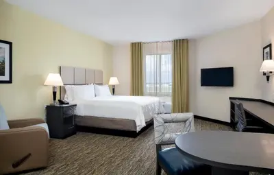 a hotel room with a bed and a table at Candlewood Suites - Miami Exec Airport - Kendall by IHG in Kendall