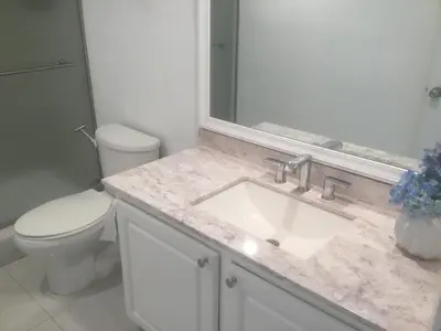 a bathroom with a sink and a toilet and a mirror at Ocean Reserve Sunny Isles in Miami Beach