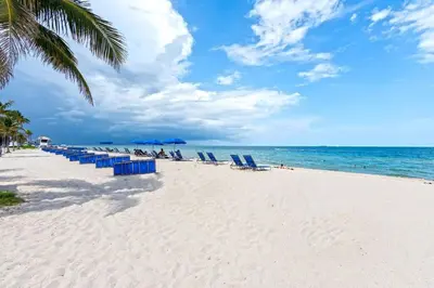 a group of beach chairs and umbrellas on a beach at Departamento en Tiffany House Fort Lauderdale beach Miami in Fort Lauderdale