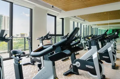 a gym with cardio machines in a building with windows at Hyde Suites Midtown Miami in Miami