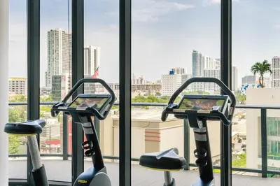 a gym with two exercise bikes in front of a window at Hyde Suites Midtown Miami in Miami