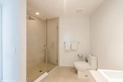 a white bathroom with a shower and a toilet at Lyfe Residence Building - Private apts over the beach in Hollywood