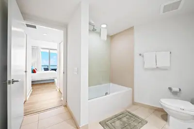 a white bathroom with a tub and a toilet at Lyfe Residence Building - Private apts over the beach in Hollywood